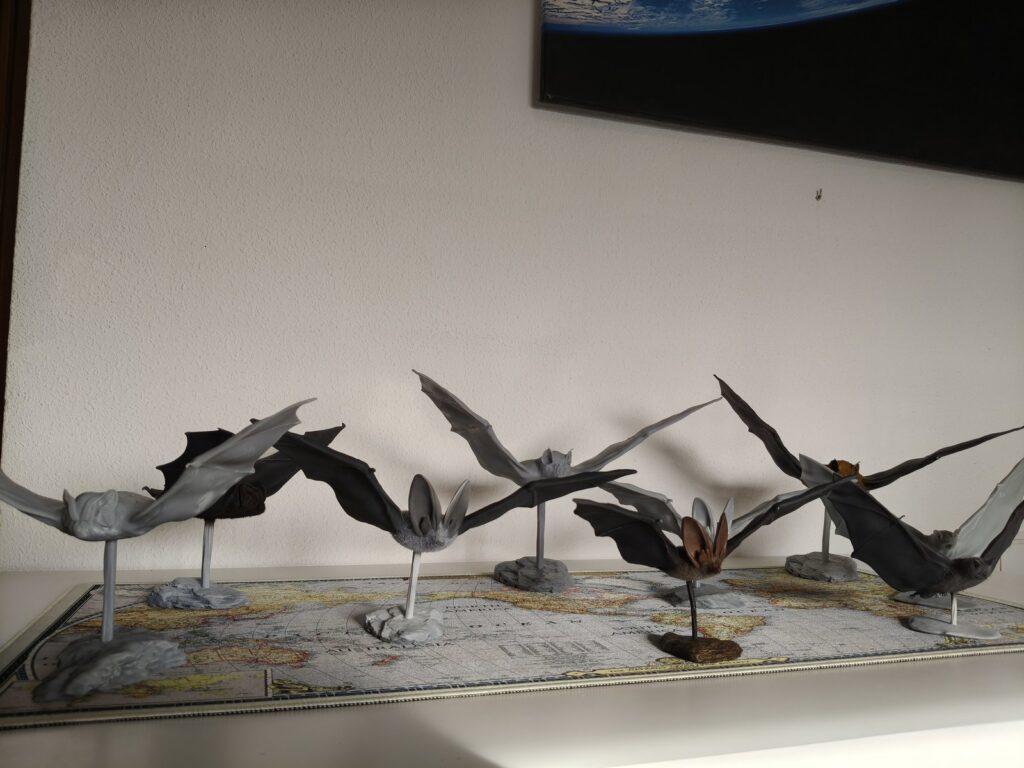 Conjunto de modelos tridimensionales de murciélagos con las alas extendidas, presentados sobre soportes.